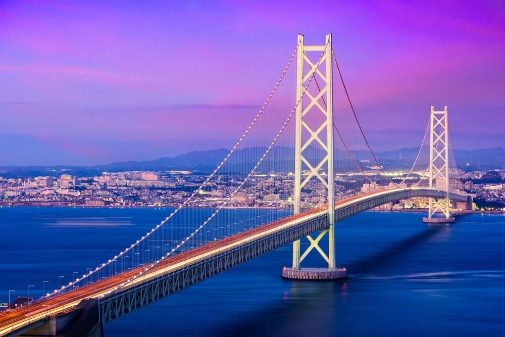 Illuminated suspension bridge at night, an example of long-span infrastructure monitored with fiber-optic sensing