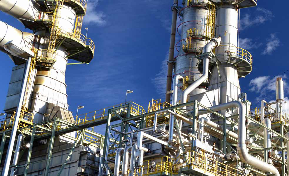 Industrial process plant with high-temperature towers and piping, an environment suited to fiber-based optical monitoring